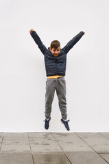 Wall Mural - Little fashionable boy posing in front of white concrete wall. Concept of style and fashion for children