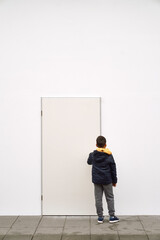 Wall Mural - Little fashionable boy posing in front of white concrete wall. Concept of style and fashion for children