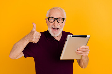 Poster - Photo of excited senior man use tablet show thumb-up approve good feedback isolated over yellow color background