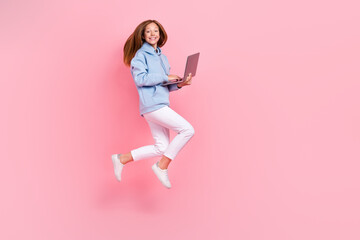 Sticker - Full length photo of excited crazy girl jump rush hold use netbook isolated on pink color background