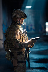 Wall Mural - Soldier of army elite forces, special security service fighter with hidden behind mask and glasses face, in helmet and load carriage system, aiming with service pistol low key.