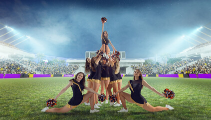 Wall Mural - Group of cheerleaders in action on  stadium in night