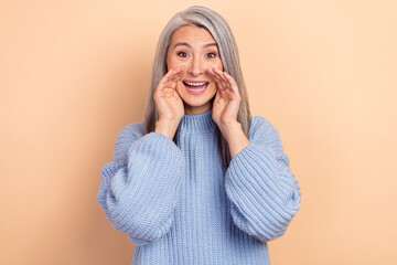 Wall Mural - Photo of good mood overjoyed female tell you latest news screaming about advertisement isolated on beige color background