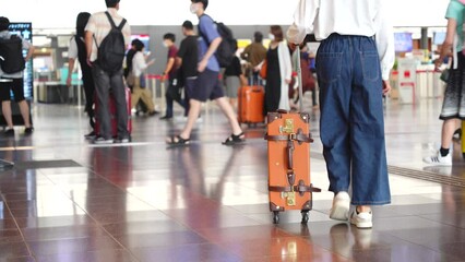 Wall Mural - 空港でキャリーバックを持って歩いている日本人の女性