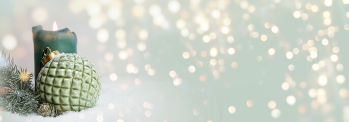 christmas background with green christmas ball and candle in the snow - festive xmas banner with gol