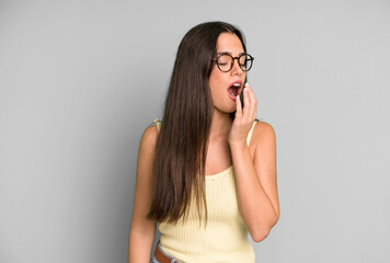 Wall Mural - hispanic pretty woman yawning lazily early in the morning, waking and looking sleepy, tired and bored