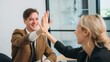 © NewSaetiew - People in the business world concluding the meeting by high fives.