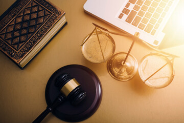 Justice and law concept.Male judge in a courtroom with the gavel, working with, computer and docking keyboard, eyeglasses, on table in morning light