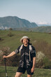 © Alina Hvostikova/Stocksy - Cheerful hiker against hills and mountains