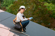 © ByLorena/Stocksy - Woman roofer putting on protective gloves in construction