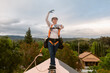 © ByLorena/Stocksy - Roofer woman on top of solar roof balancing