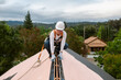 © ByLorena/Stocksy - Woman roofing on house with gables in construction work