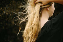 Young Woman With Long Blonde Hair Blowing In The Wind On The Coast