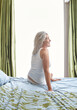 © Trinette Reed/Stocksy - Mature woman in bed in the morning