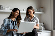 © Valentina Barreto/Stocksy - Coworkers sharing laptop in office kitchen