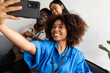 © Valentina Barreto/Stocksy - Businesspeople taking selfie in office