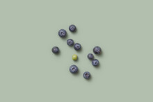 One Green Pea And Blueberries On Green Background