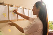 © Manu Prats/Stocksy - Asian businesswoman working with sticky notes on schedule plan