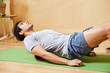 © ALTO IMAGES/Stocksy - Fit guy doing foam roller back exercise on mat at home
