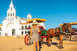 A tourist with horses and carriages in the Rocio sanctuary at the Rocio festival, Huelva. Andalusia