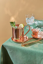 Copper Cup Of Fresh Lime Drink And Tongs For Ice.