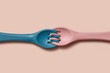 © Yaroslav Danylchenko/Stocksy - Two silicone kid forks connected with tines