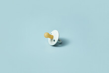 One Baby Pacifier On Blue Background.