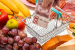 Rising food prices in Sweden, Rising inflation concept, fruit, vegetables, meat, cheese with a basket inside and a hand holding a Swedish krona banknote