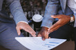 © Oleksii Syrotkin/Stocksy - Business people discussing commerce papers