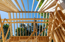 Residential Wood House Frame Under Construction Towards Peak Of Roof