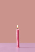 Burning Pink Candle On Pastel Background.