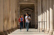 © Raymond Forbes LLC/Stocksy - Two Friends University Students walk in campus hallway outdoors