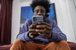 © Milles Studio/Stocksy - Black male scrolling social media on smartphone