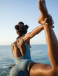 © Milles Studio/Stocksy - Black woman doing Natarajasana pose near waving sea