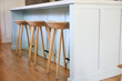 © Trinette Reed/Stocksy - Wood bar stools at kitchen island