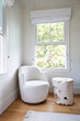 © Trinette Reed/Stocksy - Chair and side table in farmhouse bedroom