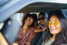 Group Of Three Women Smile For Selfie While Sitting In Car