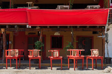 Red Table And Chairs In Front Of A Closed Restaurant Bar