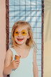 © Sergey Narevskih/Stocksy - Laughing kid with ice cream in yellow sunglasses