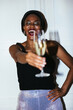 © BONNINSTUDIO/Stocksy - Joyful black woman holding champagne glass and laughing