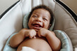 © Kristen Curette & Daemaine Hines/Stocksy - Adorable baby boy laughing in a bouncer