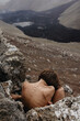 © Anastasia Mihaylova (Shpara)/Stocksy - Nude female sitting in fetal position in front of lava river