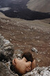 © Anastasia Mihaylova (Shpara)/Stocksy - Nude female sitting in fetal position near lava river in Iceland