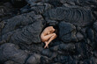 © Anastasia Mihaylova (Shpara)/Stocksy - Nude woman lying in fetal position on black solid lava in Iceland