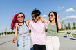 © VICTOR TORRES/Stocksy - Cheerful friends with colorful hair on street in sunny day