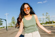 © VICTOR TORRES/Stocksy - Smiling woman in sunglasses standing on street