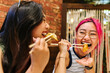 © VICTOR TORRES/Stocksy - Cheerful women eating delicious gyozas in restaurant