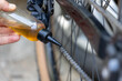 Worker lubricating bike chain with oil