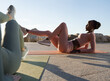 © Milles Studio/Stocksy - Sportswomen doing abs exercise on embankment
