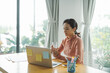 © Marc Tran/Stocksy - Young female sit at desk hold glass of water work from home